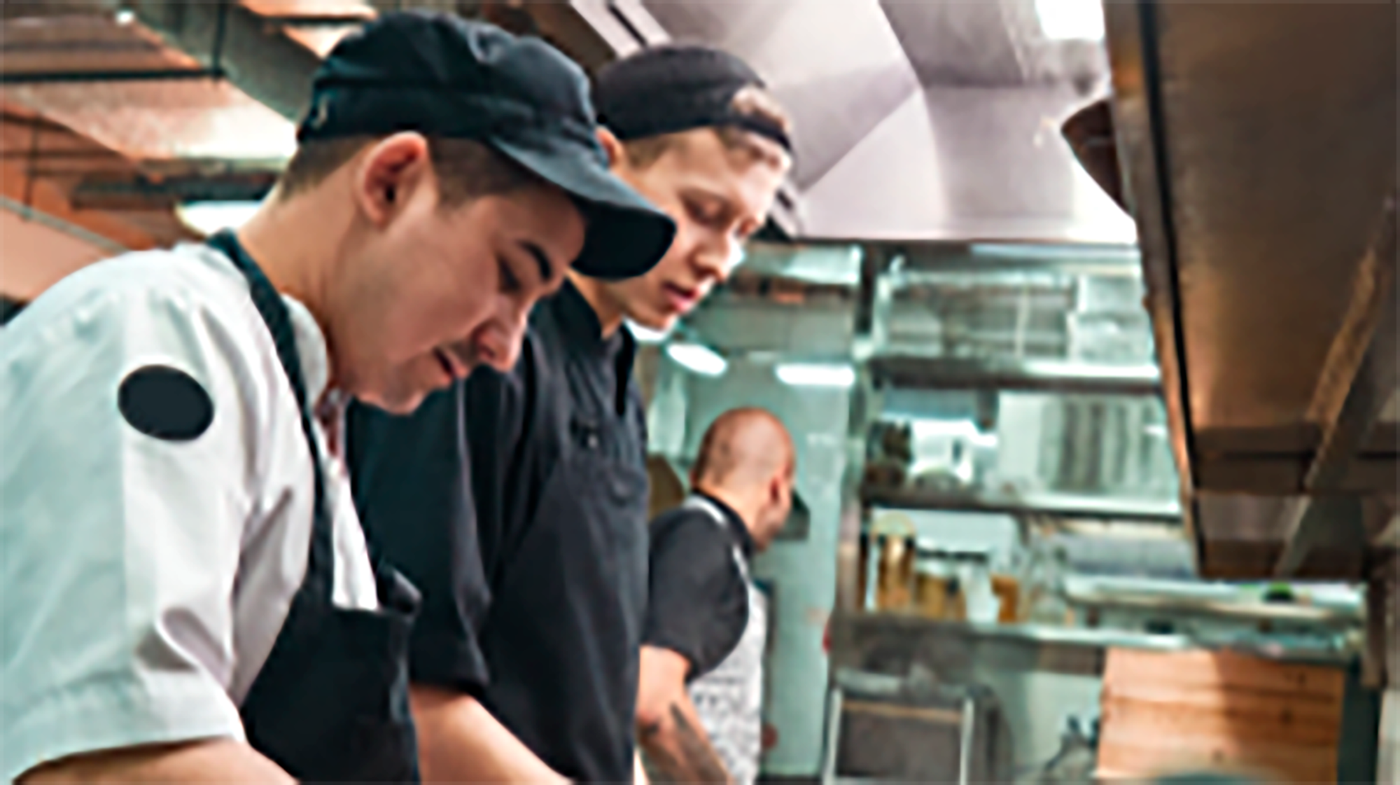 Salarié cuisine travaillant en appliquant des nomes d'hygiène et de sécurité